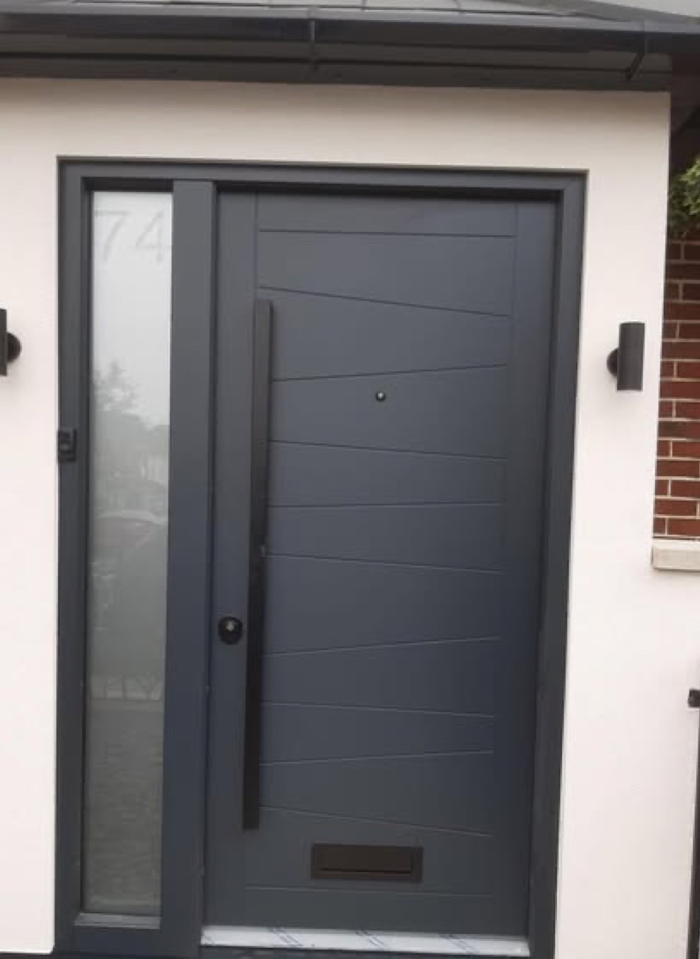 Grey contemporary front door with frosted sidelight