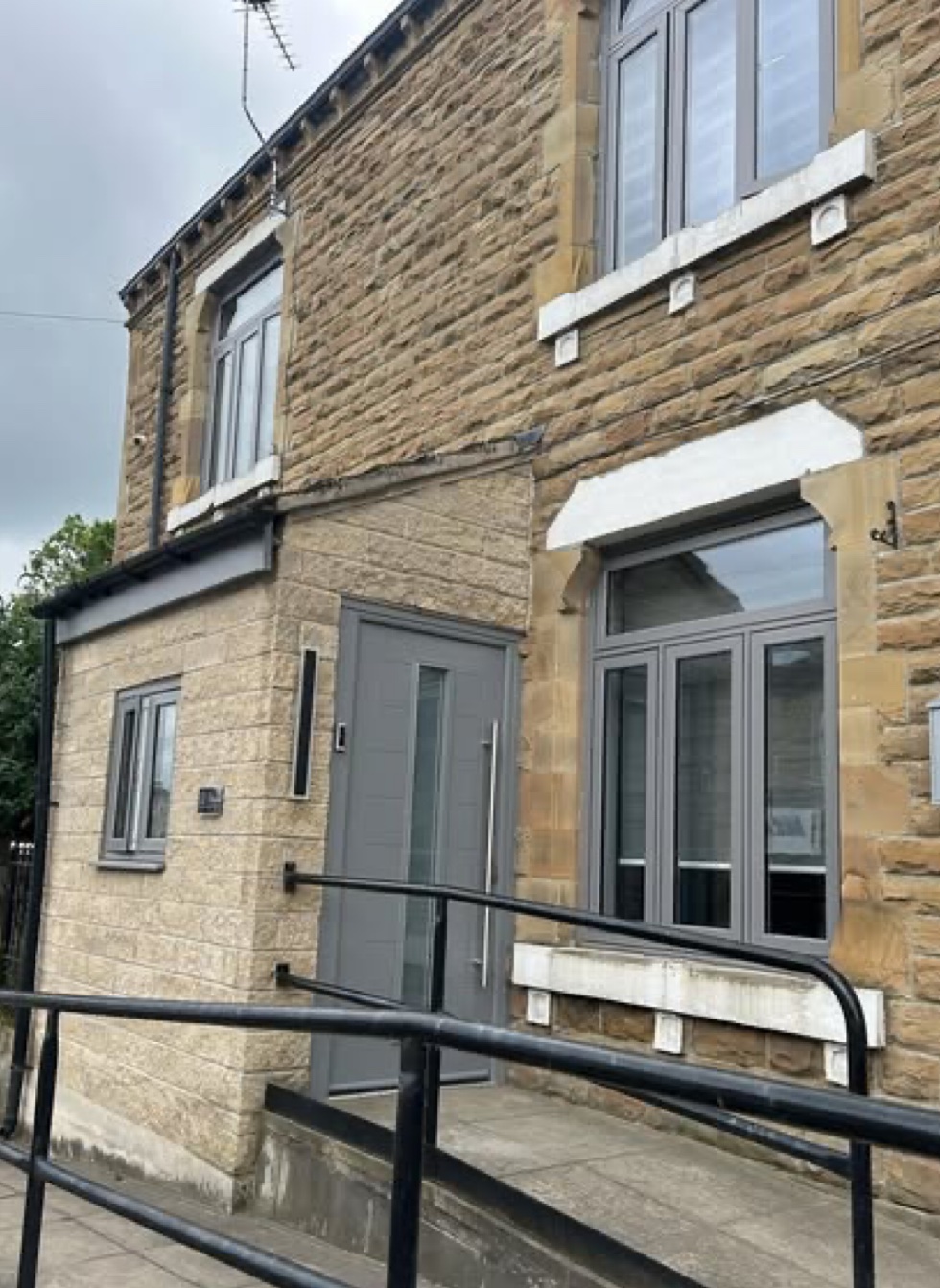 Stone cottage with grey aluminium windows and front door