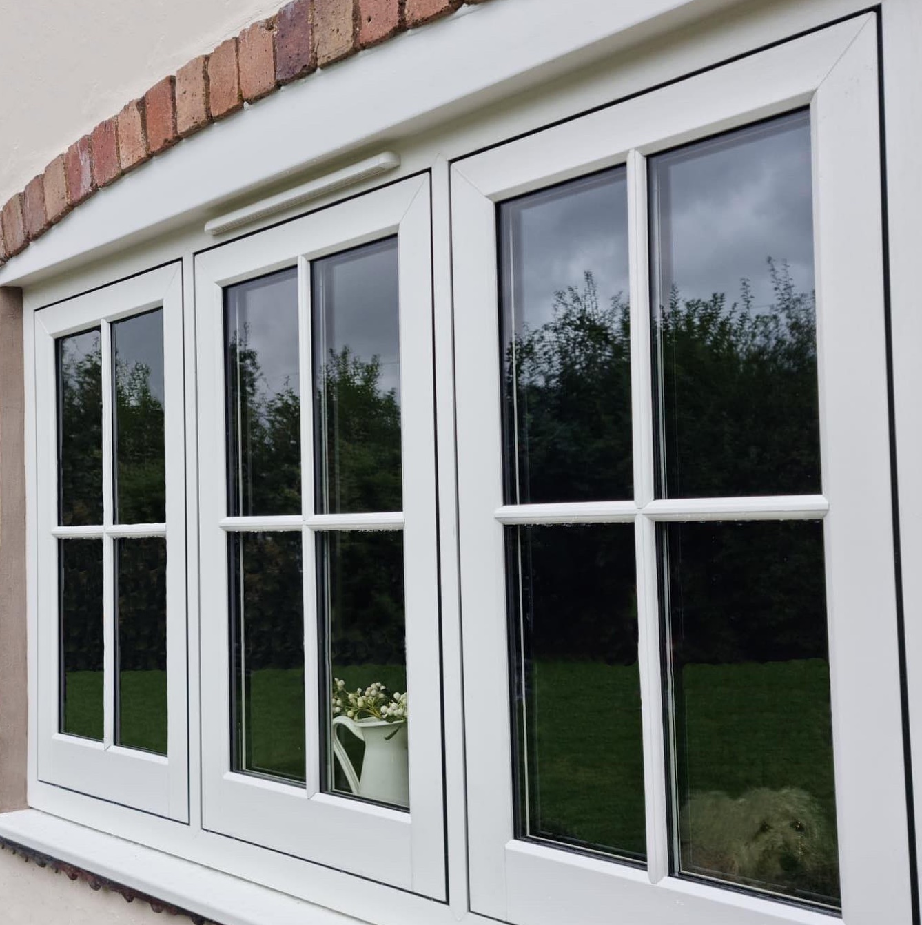 White cottage-style casement windows with astragal bars